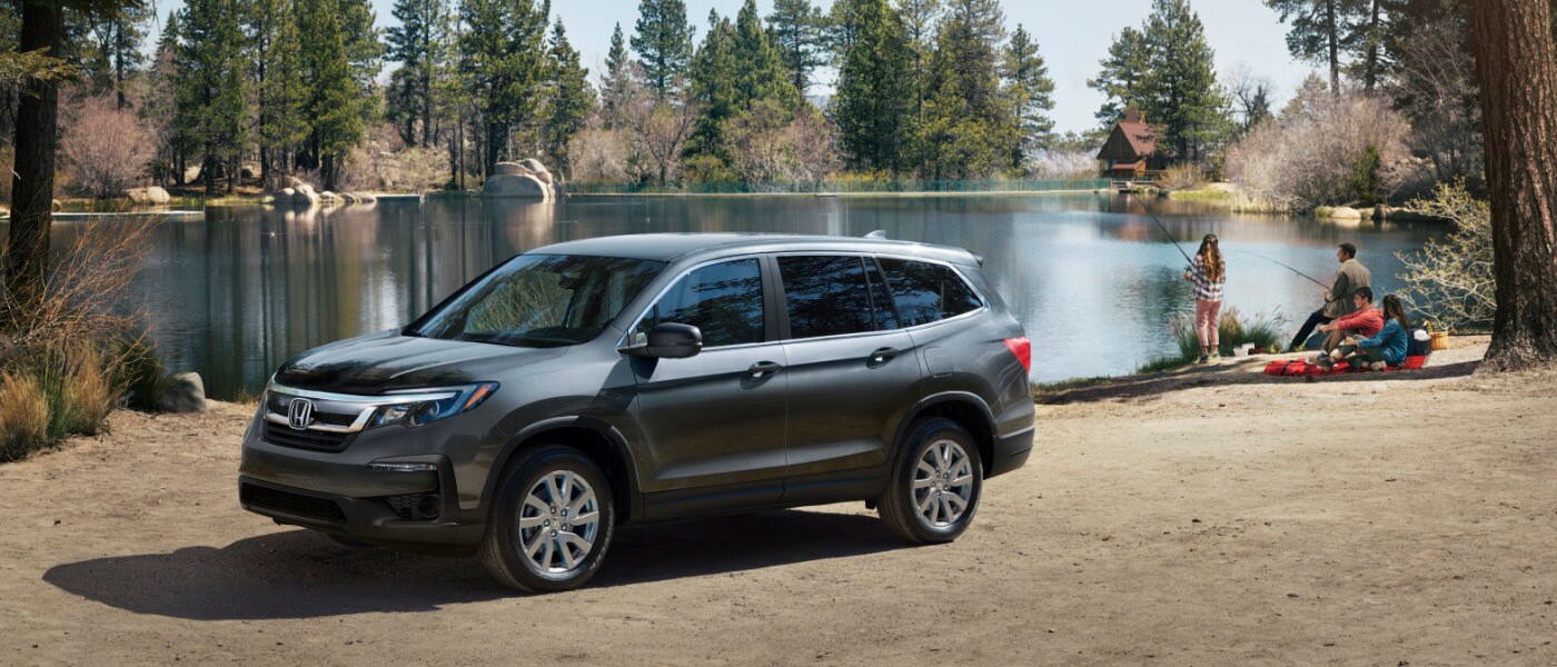 2022 Honda Pilot parked by a lake while a family is fishing