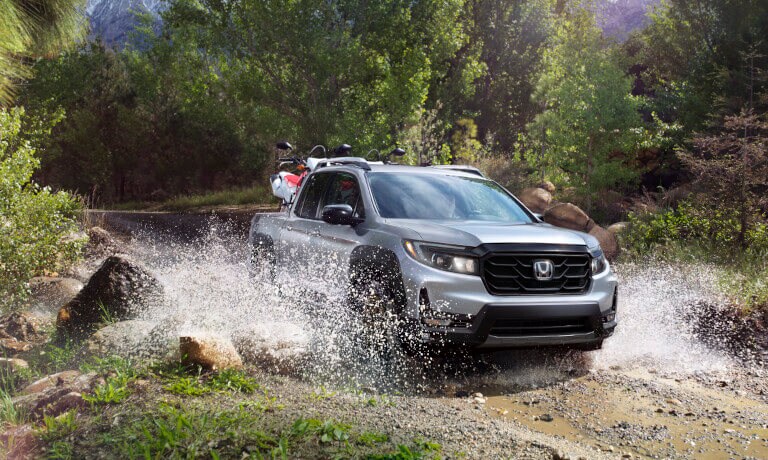 2023 Honda Ridgeline driving in a stream with bikes