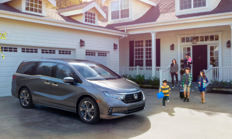 2023 Honda Odyssey parked on a driveway with a family