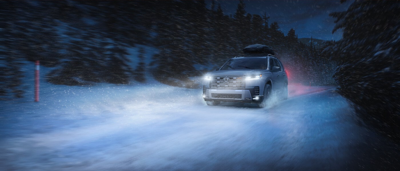 2026 Honda Pilot driving in snow with headlights