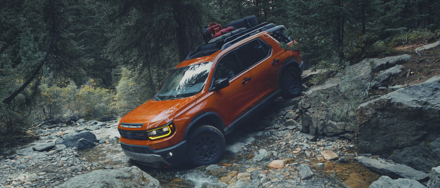 2026 Honda Passport driving over river rocks