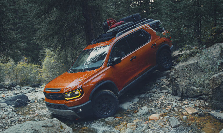 2026 Honda Passport driving over river rocks