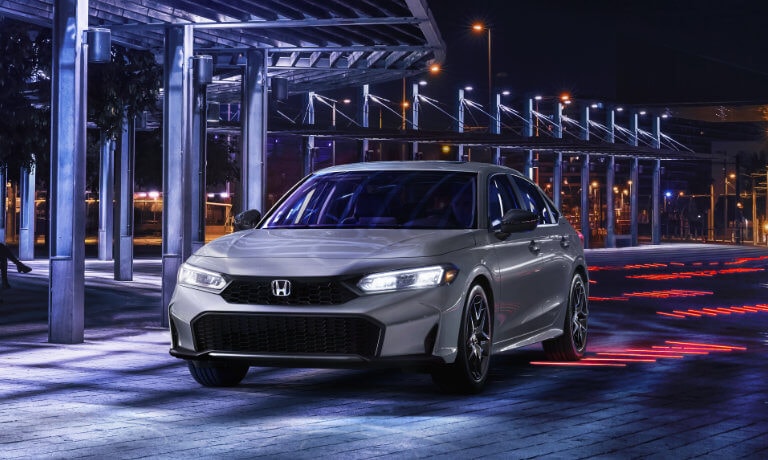 2025 Honda Civic parked by a lit promenade