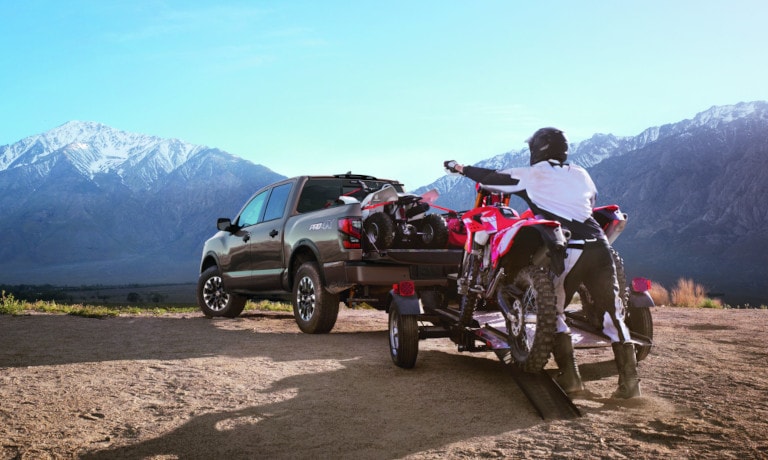 Nissan TITAN with ATVs in back and on trailer