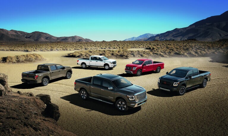 Five 2023 Nissan TITAN trucks parked in desert