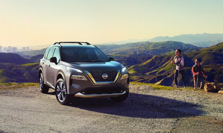 2023 Nissan Rogue parked in mountains with hikers