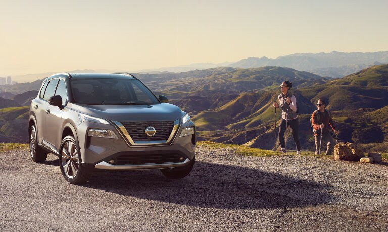 2022 Nissan Rogue parked in hills with hikers