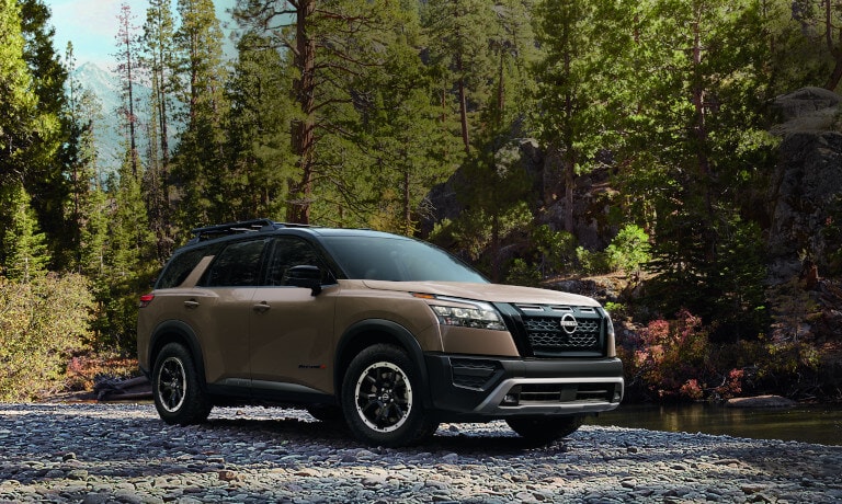 2025 Nissan Pathfinder parked by a rocky creek