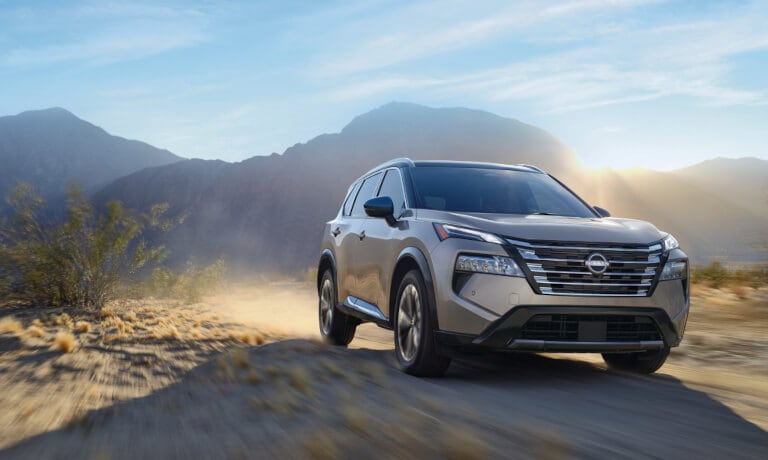 2024 Nissan Rogue driving in a dusty desert