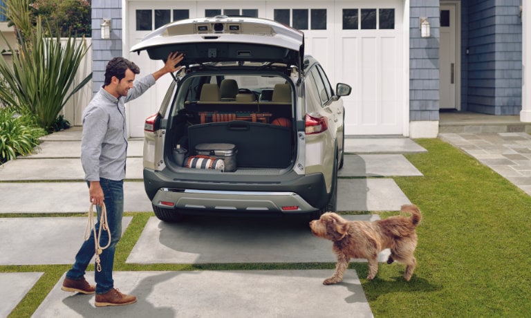 2022 Nissan Rogue with the trunk open and a very good boy ready for a walk