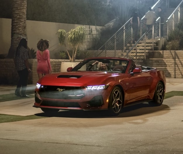 2024 Ford Mustang in red driving at party
