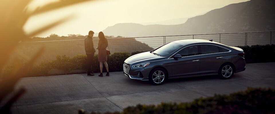 A couple watching a sunset by their Hyundai Sonata