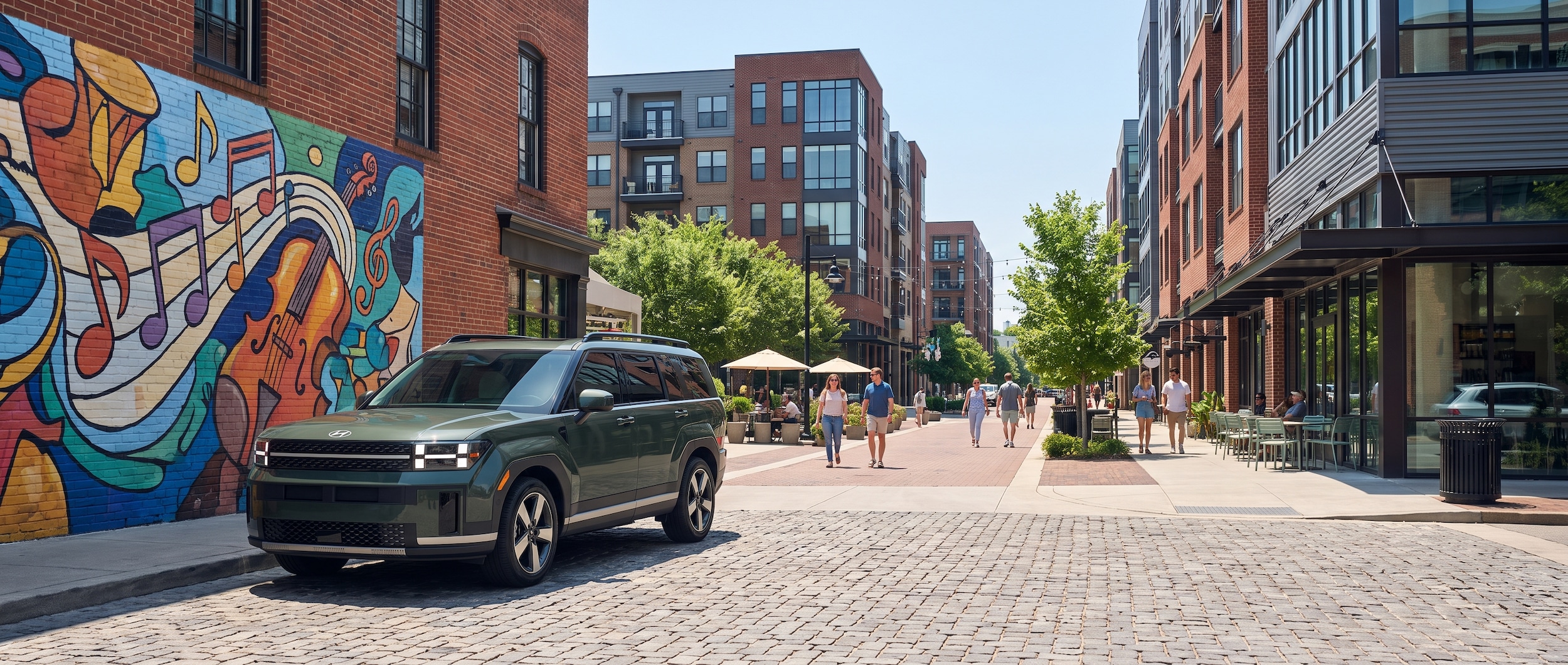 A 2026 Hyundai Santa Fe Hybrid in a modern urban setting, parked near a vibrant Nashville street mural with a walkable mixed-use district behind it, warm midday summer light, the city's brick-and-glass architecture visible in the background