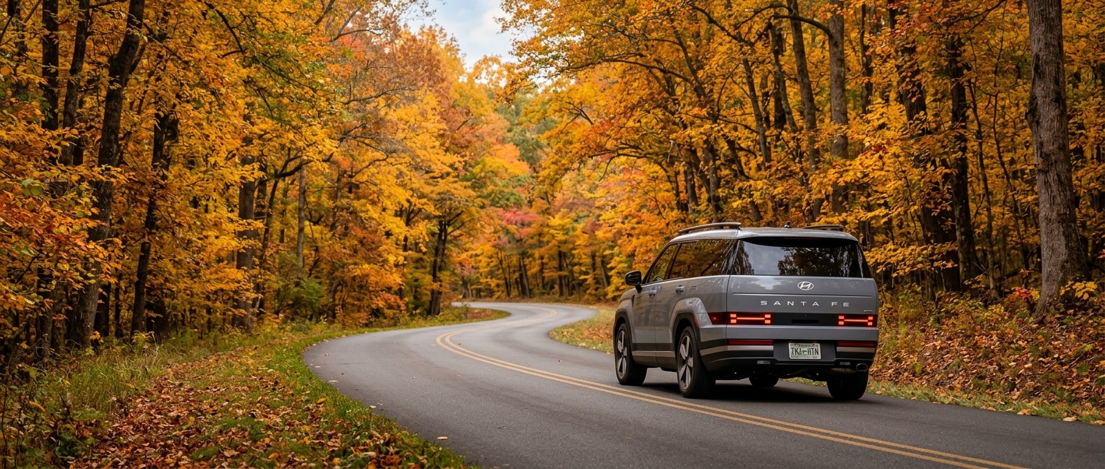 2026 Hyundai Santa Fe driving a wooded two-lane parkway road in Tennessee fall foliage