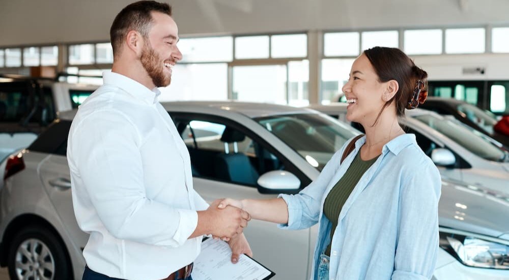 A salesman shakes a customer's hand.