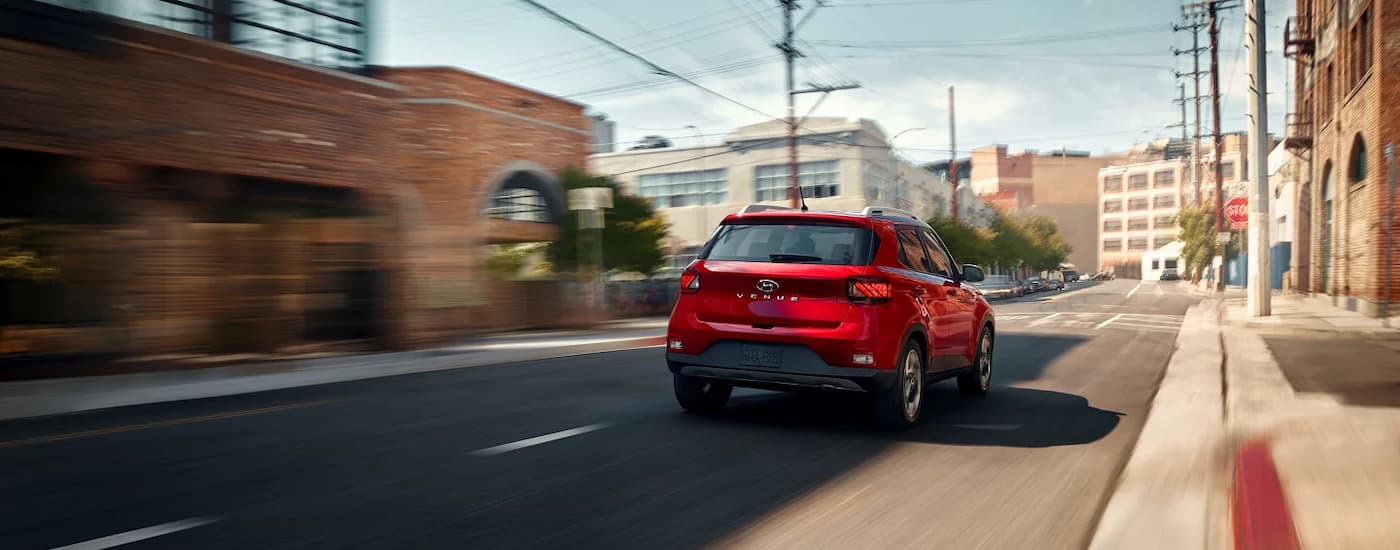 Red 2025 Hyundai Venue driving on a city street