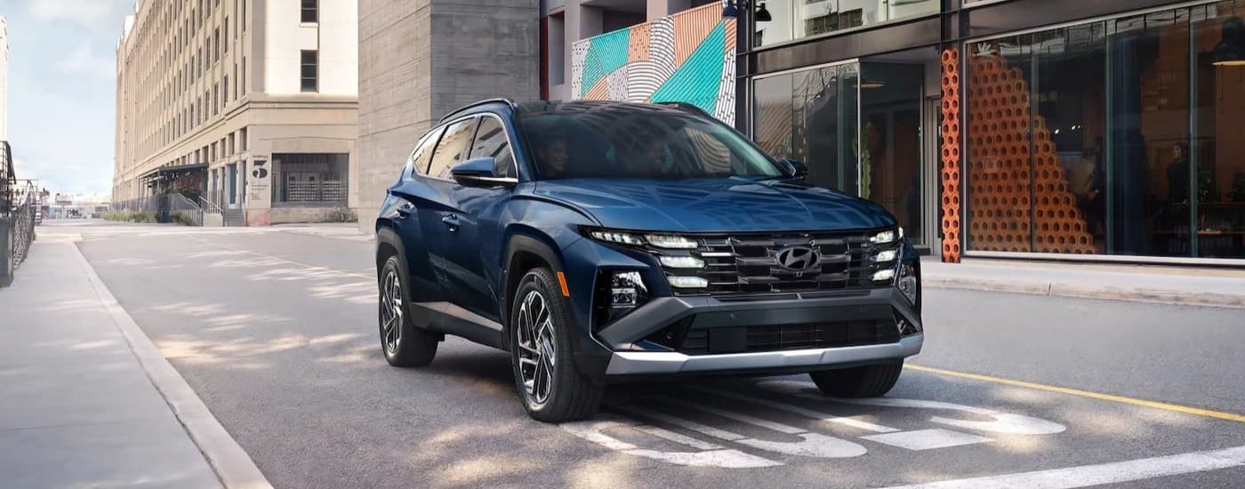 A blue 2025 Hyundai Tucson stopped at a stop sign.