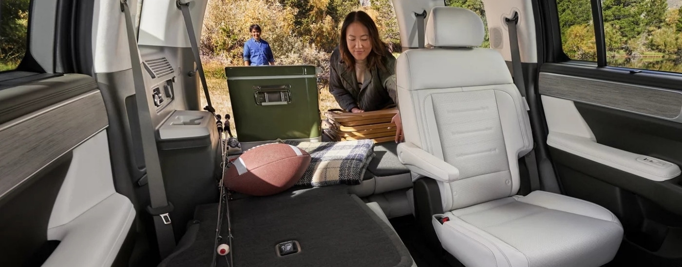 Woman getting picnic gear from the back of a 2025 Hyundai Santa Fe.