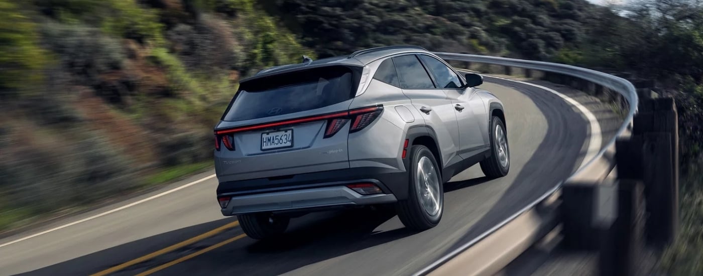 A silver 2025 Hyundai Tucson PHEV Limited rounding a corner.