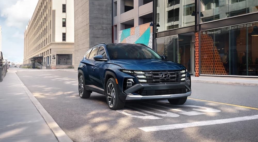 A blue 2025 Hyundai Tucson driving to a Hyundai dealer.