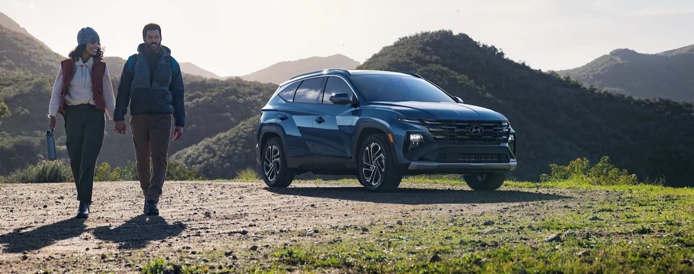 A blue 2025 Hyundai Tucson parked off-road.
