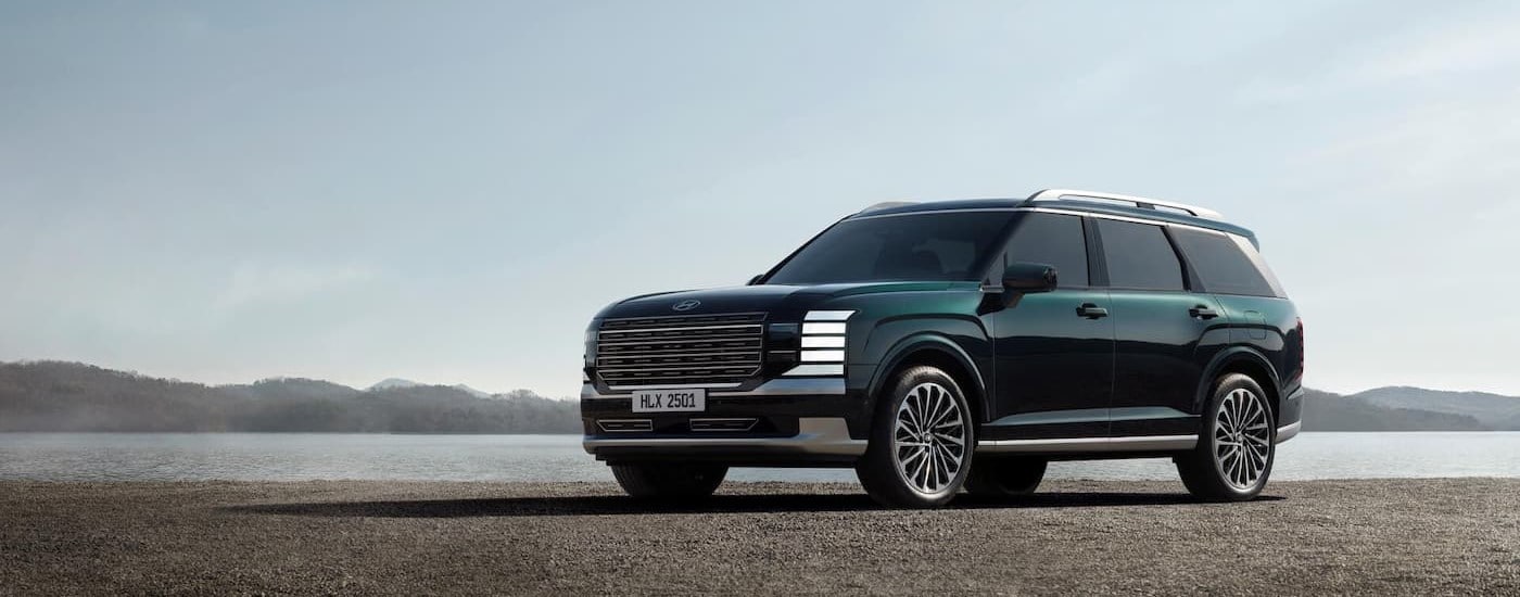 A green 2026 Hyundai Palisade parked near a lake.