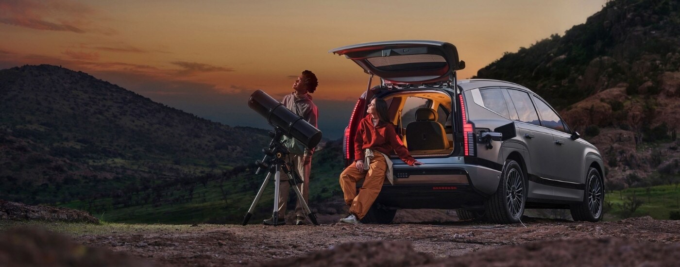 People using a telescope near a silver 2026 Hyundai IONIQ 9 Calligraphy.