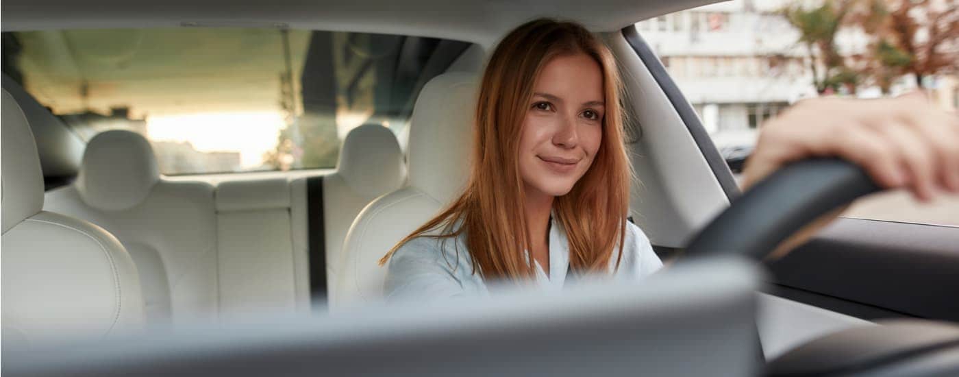 A woman is driving in her vehicle she wants to sell.