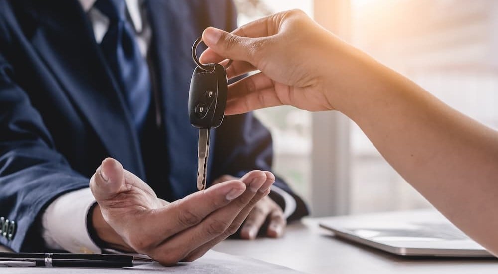 A customer is handing a key over to a buyer.