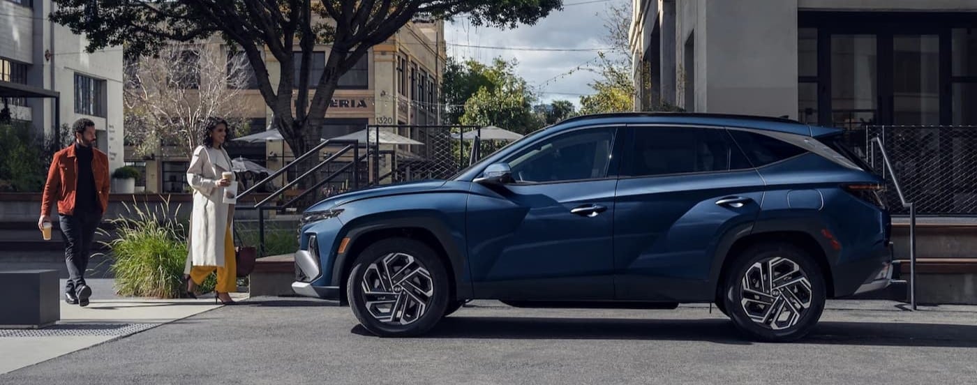 A blue 2025 Hyundai Tucson for sale parked in a city.