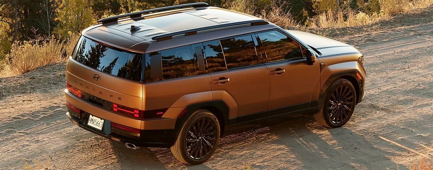Brown 2025 Hyundai Santa Fe driving on a dirt road