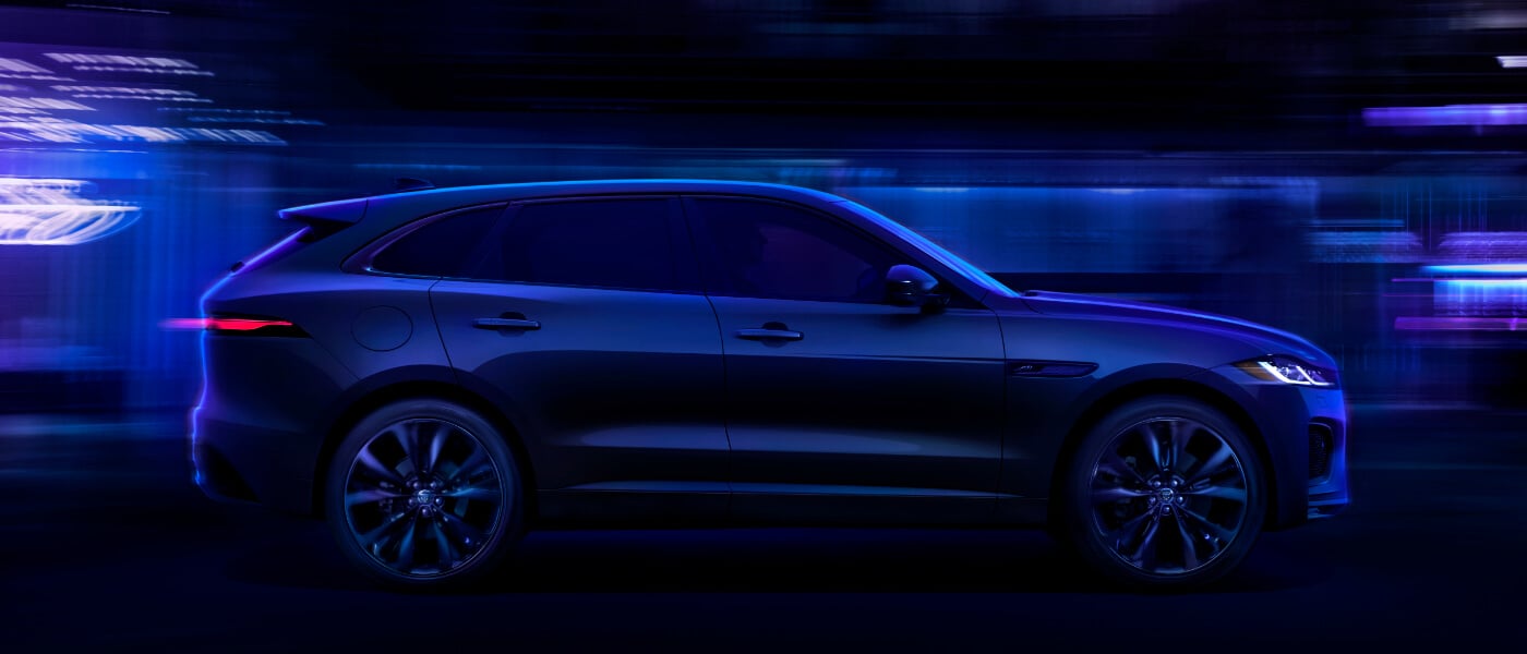 2026 Jaguar F-PACE driving in a blue tunnel at night