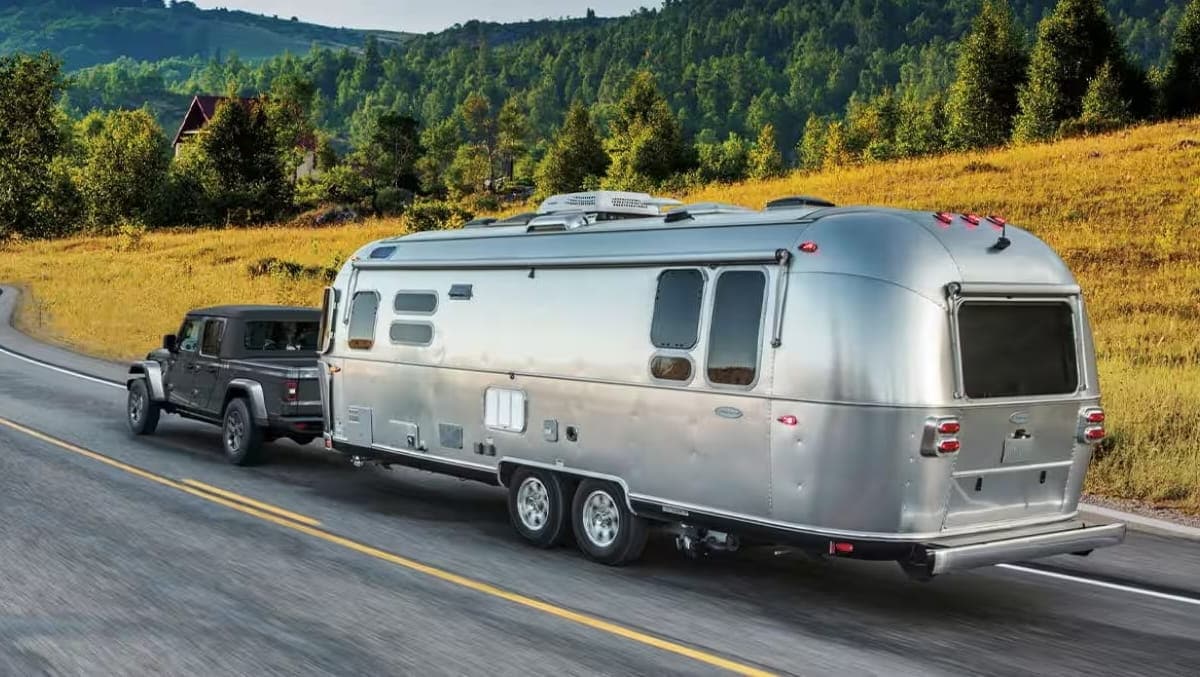 Jeep Gladiator towing a travel trailer on an open road