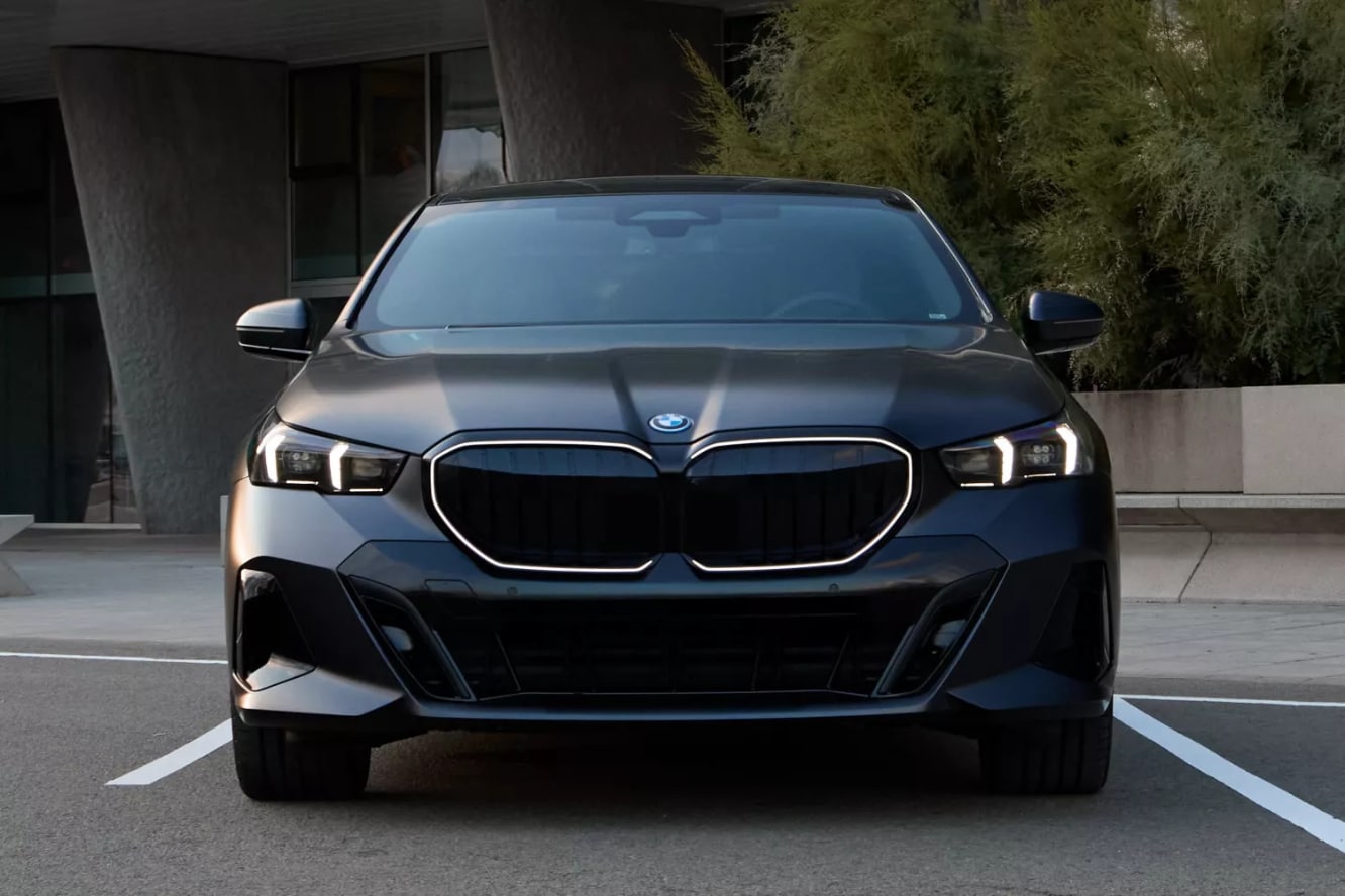 A front view of a black BMW 5 Series parked in front of a building.
