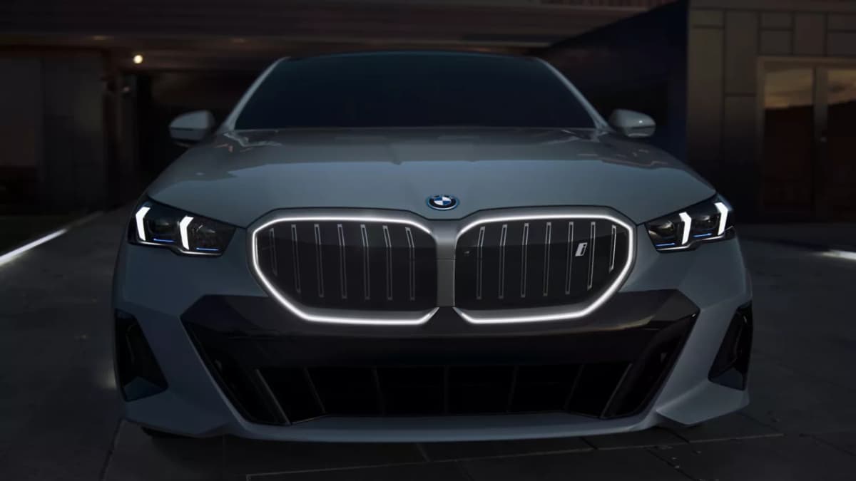 A front view of a dark grey BMW i5 at night.