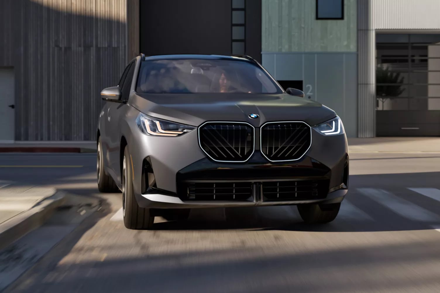 A gray BMW X3 being driven through a town. A gray BMW X3 being driven through a town.