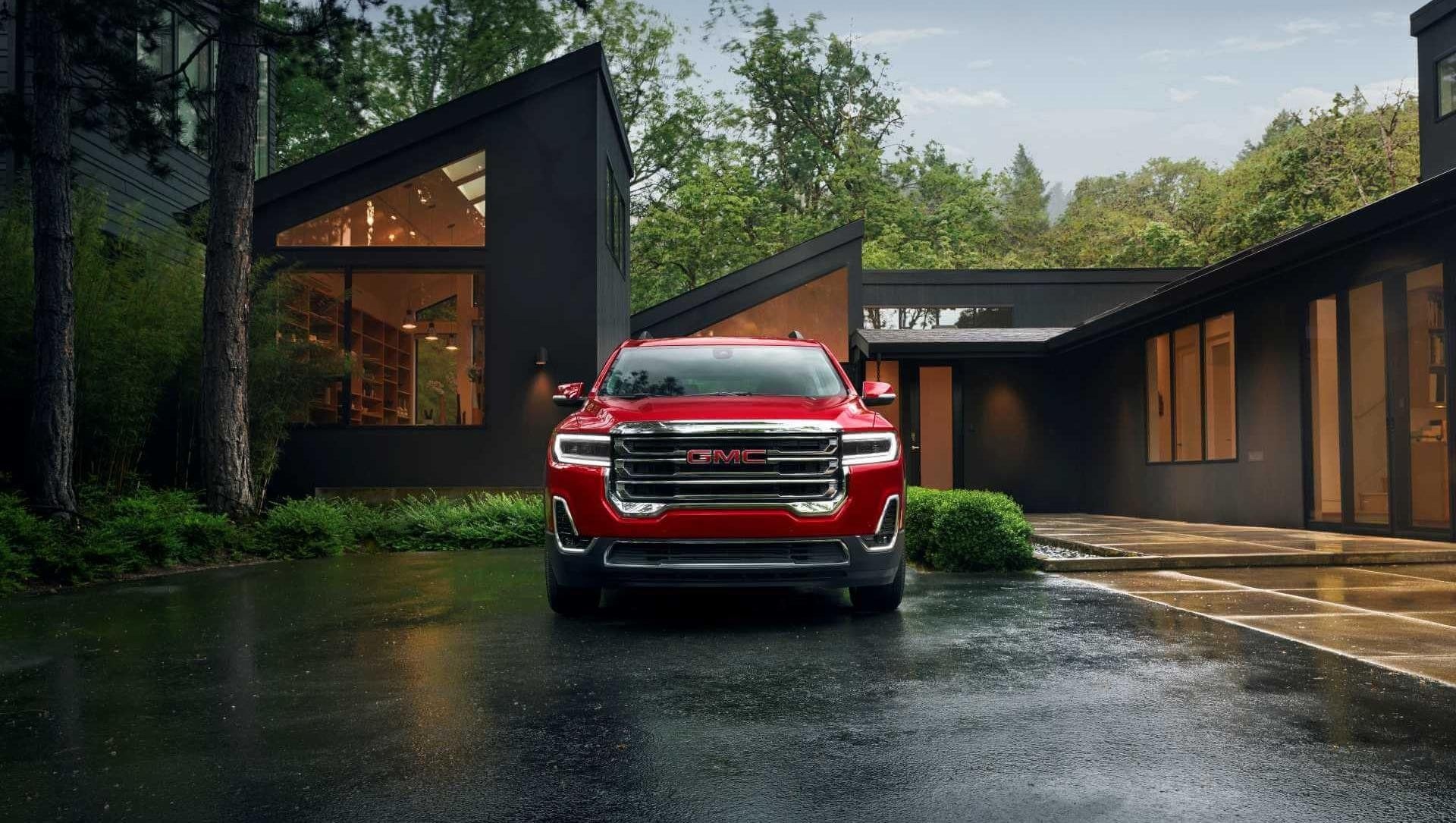 Red GMC Acadia sitting on rainy driveway in Washington State