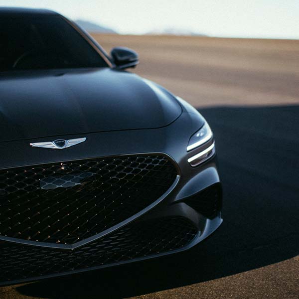 Model Features of the 2022 Genesis G70 at Genesis of York | Close-Up View of Grill & Headlight on a Dark Silver 2022 Genesis G70