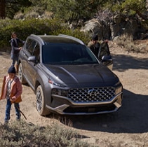 Model Features of the 2022 Hyundai Santa Fe at Jack Giambalvo Hyundai | Santa Fe parked while family climbs mountain