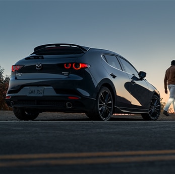 The 2021 Mazda3 vs. The 2021 Mazda6 at Jack Giambalvo Mazda | Back of Mazda3 Hatchback parked during sunset