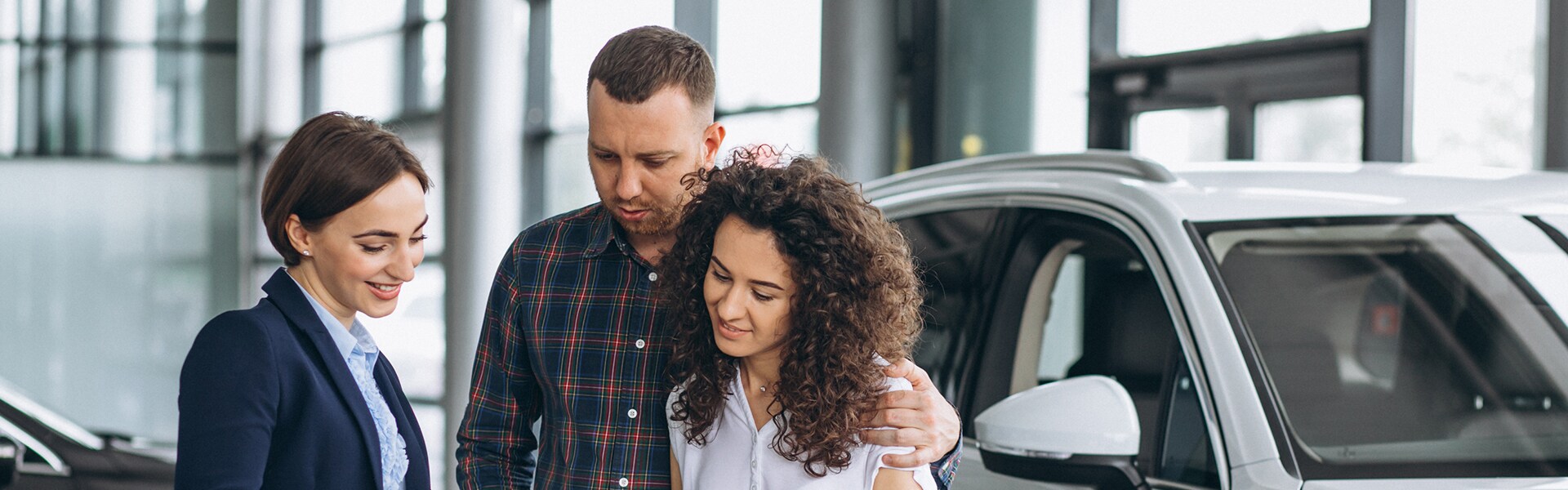 Jack Giambalvo Mazda is a Car Dealership in Dillsburg, PA | A sales representative speaking with a young couple purchasing a car