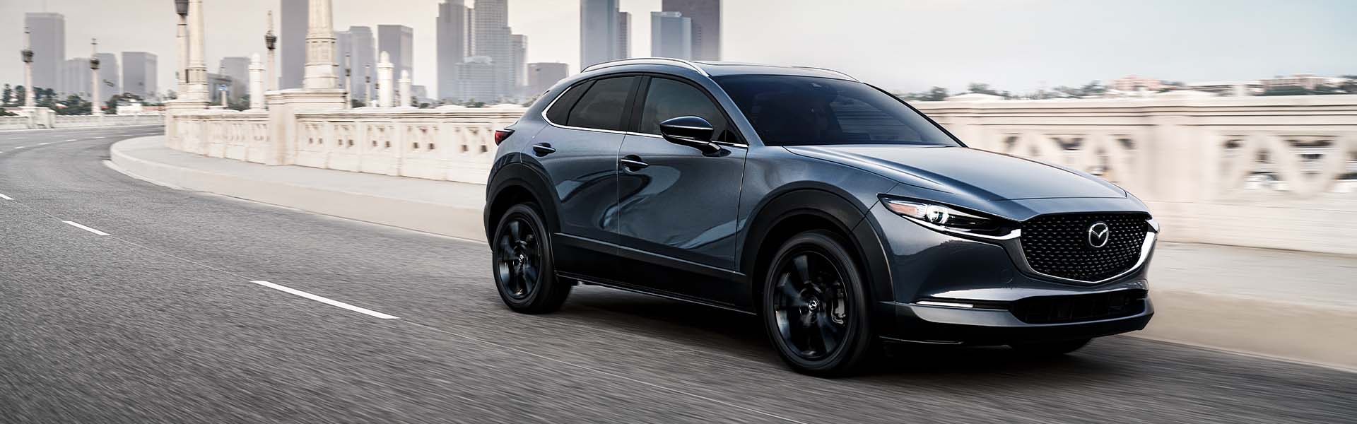 Model Features of the 2021 Mazda CX-30 at Jack Giambalvo Mazda | Blue 2021 Mazda CX-30 Driving Out of City