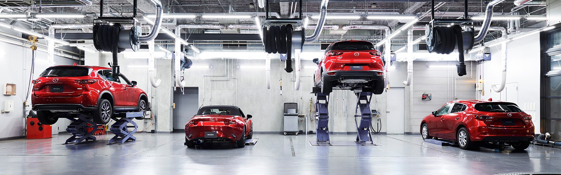 Brake replacement and Safety at Jack Giambalvo Mazda | Multiple Red Mazda Vehicles Waiting to Be Worked on in Service Bay