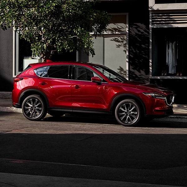 The 2022 Mazda CX-5 vs. The 2022 Mazda CX-30 at Jack Giambalvo Mazda | Red 2022 Mazda CX-5 Street Parked in City