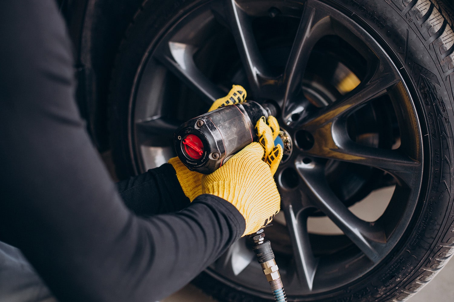 What is a Tire Rotation? at Jack Giambalvo Mazda | Mazda service technician taking wheel off of a vehicle to rotate the tires
