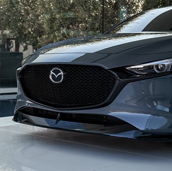 The 2021 Mazda3 vs. The 2021 Mazda6 at Jack Giambalvo Mazda | Close-up of Mazda3's front in park