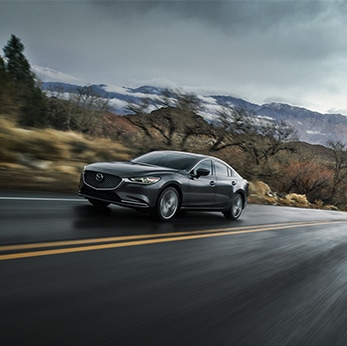 The 2021 Mazda3 vs. The 2021 Mazda6 at Jack Giambalvo Mazda | Mazda6 speeds by on wet road