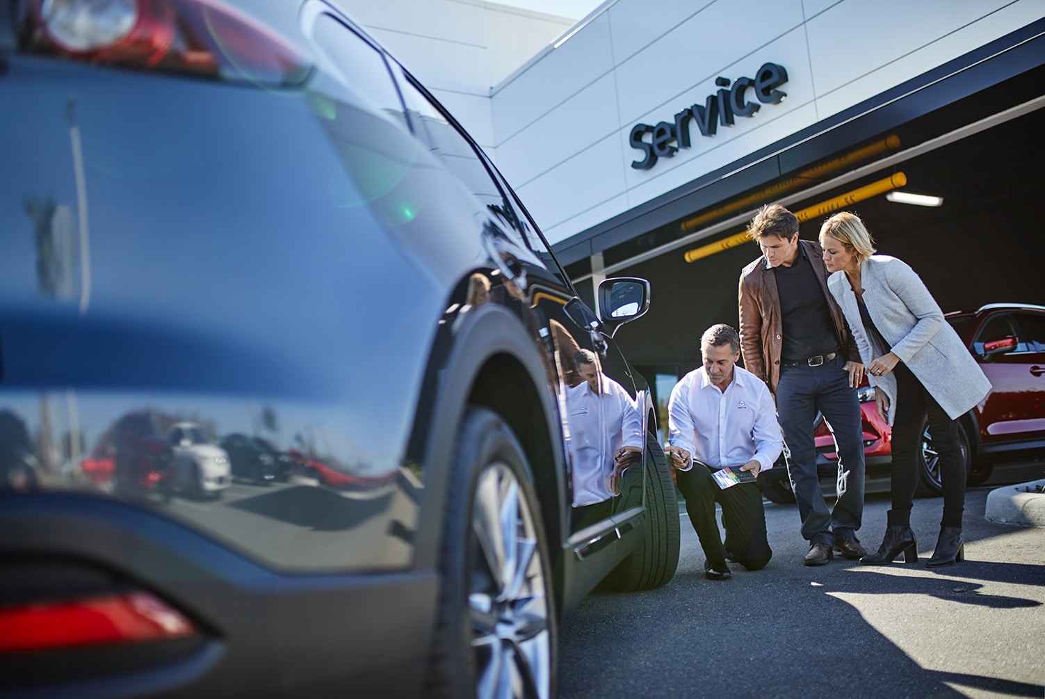How to Check your Tires' Health at Jack Giambalvo Mazda | Mazda sales associate checking tire pressure for customers