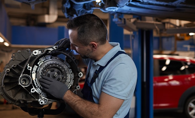 Jack Giambalvo Mazda is a Car Dealership in Dillsburg, PA | An Auto mechanic examining the torque converter on a transmission