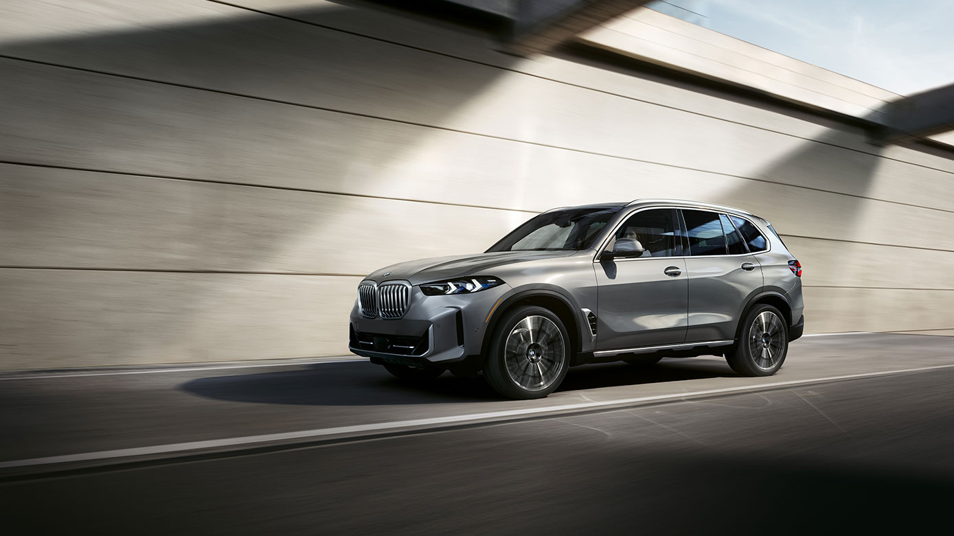silver BMW X5 driving in the city